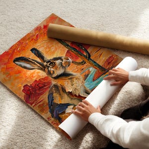 Puede incluir: Una impresi&oacute;n art&iacute;stica cuadrada que presenta una pintura al &oacute;leo de una liebre en un paisaje des&eacute;rtico con un cactus. La obra utiliza pinceladas gruesas y texturizadas en tonos vibrantes de naranja, rojo y azul. Un tubo de env&iacute;o de cart&oacute;n marr&oacute;n se encuentra cerca.