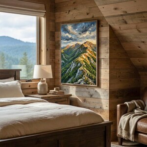 May include: A rectangular wall art print featuring an oil painting of a mountain range with green slopes, rocky peaks, and a dramatic cloudy sky. The artwork is displayed in a vertical orientation on a wooden wall above a bedside table.