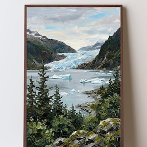 May include: An oil painting in a brown frame depicting a glacier landscape with a light blue icy river flowing between dark green mountains. The foreground features textured dark green pine trees and rocky terrain with small icebergs floating in the water.
