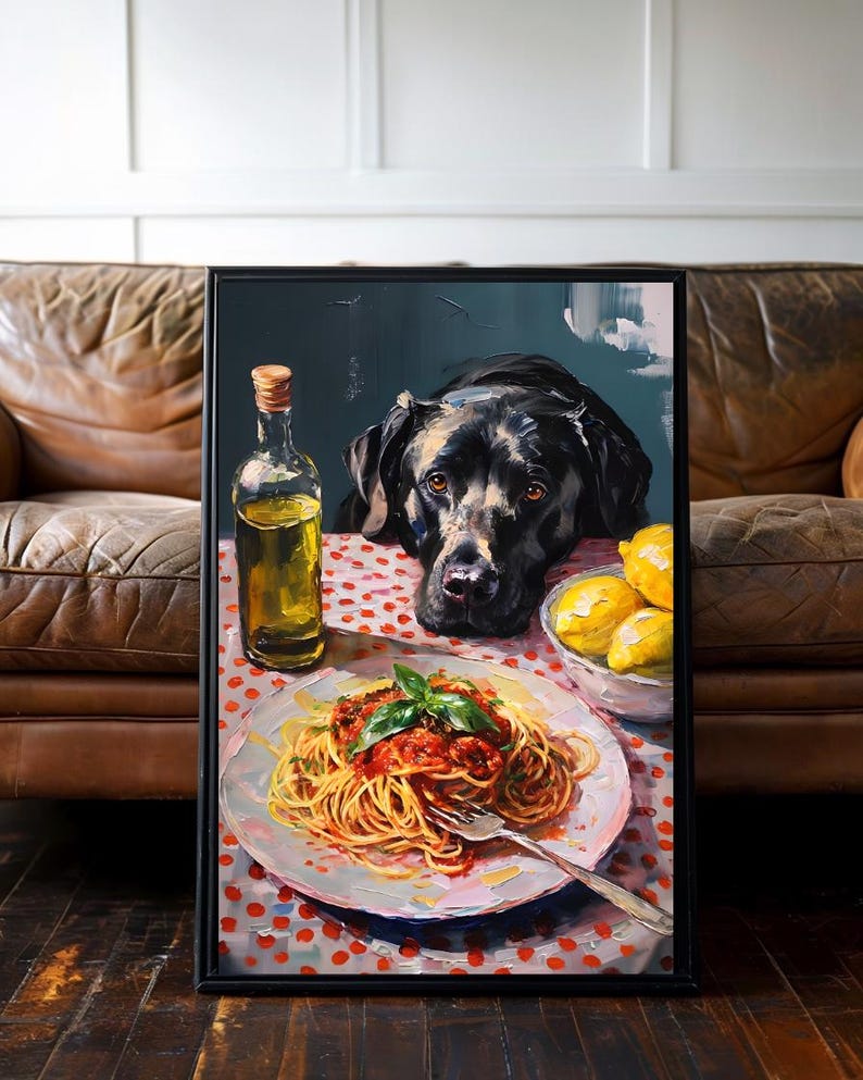 Pode incluir: Obra de arte emoldurada que retrata um c&atilde;o preto olhando para um prato de espaguete com molho de tomate e manjeric&atilde;o. Uma garrafa de azeite e uma tigela de lim&otilde;es tamb&eacute;m est&atilde;o sobre a mesa. A mesa &eacute; coberta com uma toalha de mesa de bolinhas vermelhas e brancas.