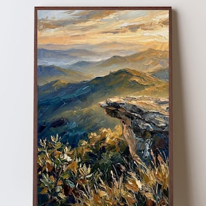 Puede incluir: Una pintura al óleo en un marco marrón oscuro que representa un paisaje de montaña al atardecer. La escena presenta un prominente borde de acantilado rocoso en primer plano, cadenas montañosas azules y verdes y un cielo dorado texturizado.