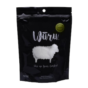 May include: Black package with the word "Würu" in white script, a white sheep graphic, and the text "Step up your Comfort." The package also states "100% Premium New Zealand Wool" and "Net Weight 75oz (21g)." A gold sticker reads "Premium Blister Prevention."