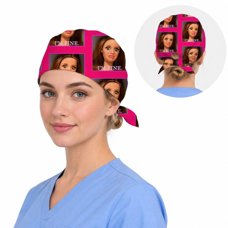 Peut inclure: Une charlotte de bloc op&eacute;ratoire avec un motif r&eacute;p&eacute;titif repr&eacute;sentant un visage de poup&eacute;e aux cheveux bruns et le texte I'M FINE. Le design est sur un fond rose vif avec des lignes de grille rose fonc&eacute;. La charlotte se noue &agrave; l'arri&egrave;re.