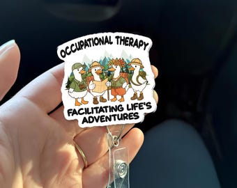 Könnte beinhalten: Ein weißes Abzeichen mit den Worten "OCCUPATIONAL THERAPY" und "FACILITATING LIFE'S ADVENTURES". Das Abzeichen zeigt vier Cartoon-Enten, die als Wanderer gekleidet sind, mit Rucksäcken und Hüten. Die Enten stehen vor einer grünen und blauen Berglandschaft.