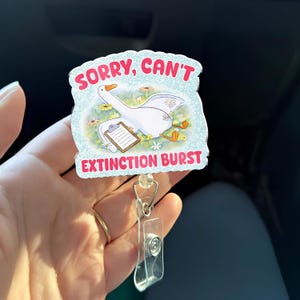 Może przedstawiać: Odznaka z ilustracją kreskówki gęsi. Odznaka ma tekst "Sorry, Can't" i "Extinction Burst" w kolorze różowym i czerwonym. Gęś jest biała z żółtymi stopami i schowkiem.