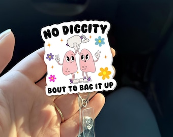Puede incluir: Un portatarjetas blanco con el texto "NO DIGGITY" y "BOUT TO BAG IT UP". La insignia presenta dos pulmones de dibujos animados con brazos y piernas, sosteniendo una botella. Flores y estrellas coloridas rodean el texto y los pulmones.