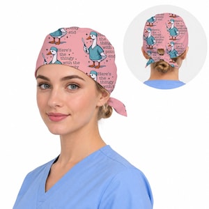 Pu&ograve; includere: Una cuffia chirurgica rosa con un motivo ripetuto di un'oca bianca che indossa una casacca e una cuffia chirurgica color verde acqua, mentre tiene in mano un bisturi. Il testo "Here's the thingy with the pointy end" &egrave; stampato in nero accanto all'oca.