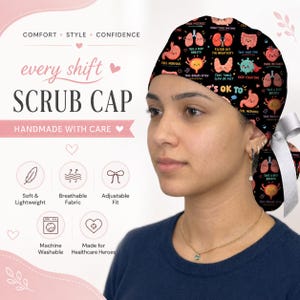 May include: A black scrub cap featuring a colorful pattern of cartoon human organs with motivational text including "Take a deep breath," "Filter out the negativity," and "It's ok to." The cap includes a white ribbon tie at the back for an adjustable fit.