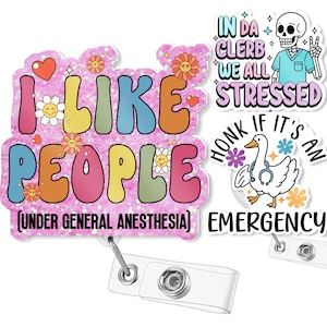Op de afbeelding: Een verzameling kleurrijke badge reels met verschillende ontwerpen en tekst. Eén leest "I LIKE PEOPLE (UNDER GENERAL ANESTHESIA)", een andere zegt "IN DA CLERB WE ALL STRESSED", en een derde zegt "HONK IF IT'S AN EMERGENCY".