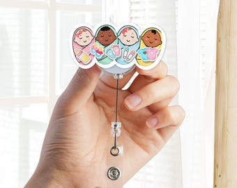 May include: A retractable badge reel featuring four cartoon babies of different skin tones. The babies are in swaddles with various accessories like a bottle, footprints, and safety pins. The reel has a clear plastic strap and a metal clip.