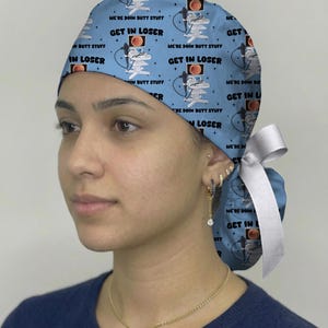 May include: A light blue scrub cap featuring a repeating pattern of medical endoscopy equipment and the text "GET IN LOSER" and "WE'RE DOIN BUTT STUFF". The cap includes a white ribbon tie at the back to secure the fabric in a ponytail style.