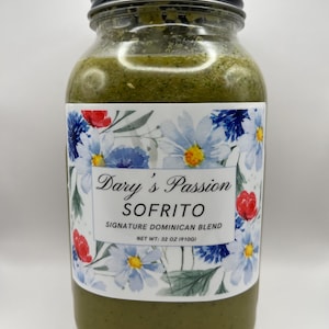 May include: A clear glass jar filled with a green mixture, topped with a black lid. The jar has a label with the text "Dary's Passion SOFRITO Signature Dominican Blend." The label features blue and white flowers with red accents. Net weight is 32 oz (910g).