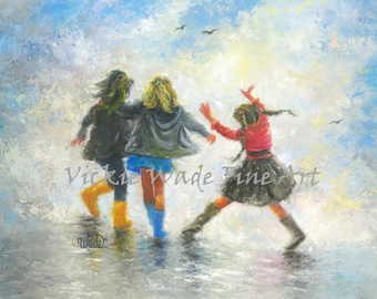 May include: Three girls wearing rain boots and jackets walk in a puddle. The girl in the middle is wearing blue boots, the girl on the left is wearing yellow boots, and the girl on the right is wearing black boots. The sky is blue with white clouds.