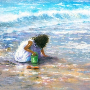 Può includere: Una bambina con un vestito bianco gioca su una spiaggia sabbiosa con un secchiello verde e una paletta arancione. Le onde dell'oceano sono sullo sfondo.