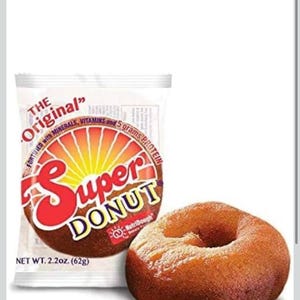 May include: An image of a Super Donut, a packaged donut with the words "Super Donut" in red and yellow. The package states it is fortified with minerals, vitamins, and 5 grams of protein. A single donut is next to the package.