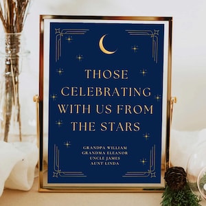 May include: A navy blue sign with gold lettering and a crescent moon and stars. The sign reads "Those Celebrating With Us From The Stars" and lists names: Grandpa William, Grandma Eleanor, Uncle James, Aunt Linda.