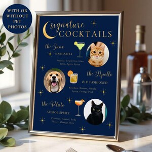 May include: A vertical rectangular sign in a silver frame with a dark blue background featuring gold text and star accents. It lists three signature cocktails: The Luna Margarita, The Apollo Old Fashioned, and The Pluto Aperol Spritz, each paired with a photo of a pet and a drink illustration.