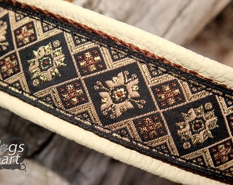 May include: Close-up of a black leather dog collar with a brown and gold patterned fabric trim. The fabric has a geometric design with small flowers.