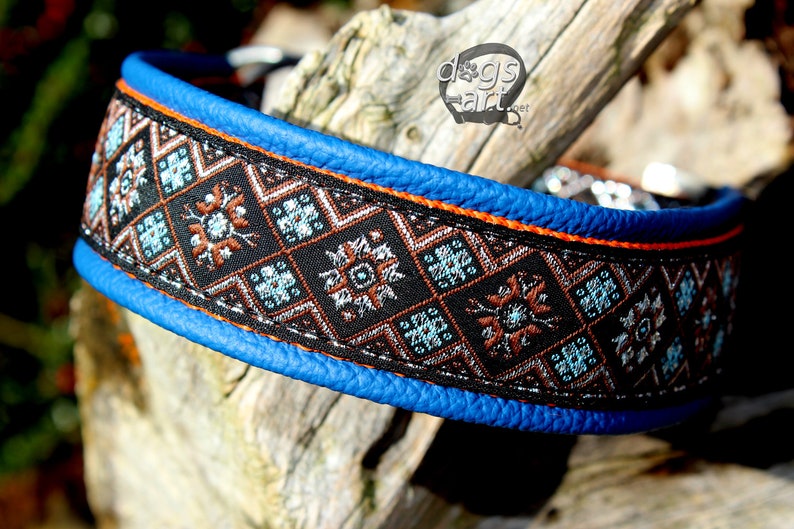 May include: A blue leather dog collar with an orange trim and a black and brown patterned fabric insert. The fabric has a geometric design with blue, silver, and orange accents.