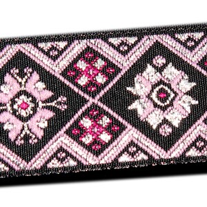 May include: Black ribbon trim with a pink and silver geometric pattern. The pattern features repeating diamond shapes with floral designs.