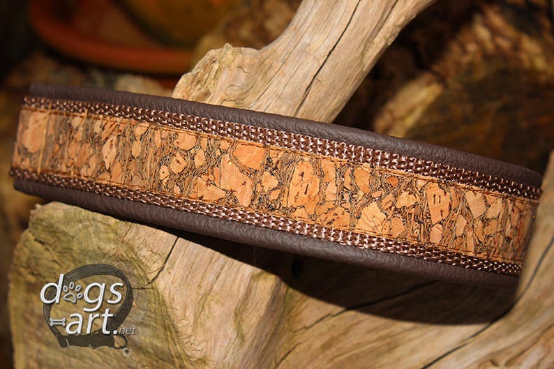 May include: A brown leather dog collar with a cork and brown fabric trim. The collar has a decorative pattern of cork pieces.