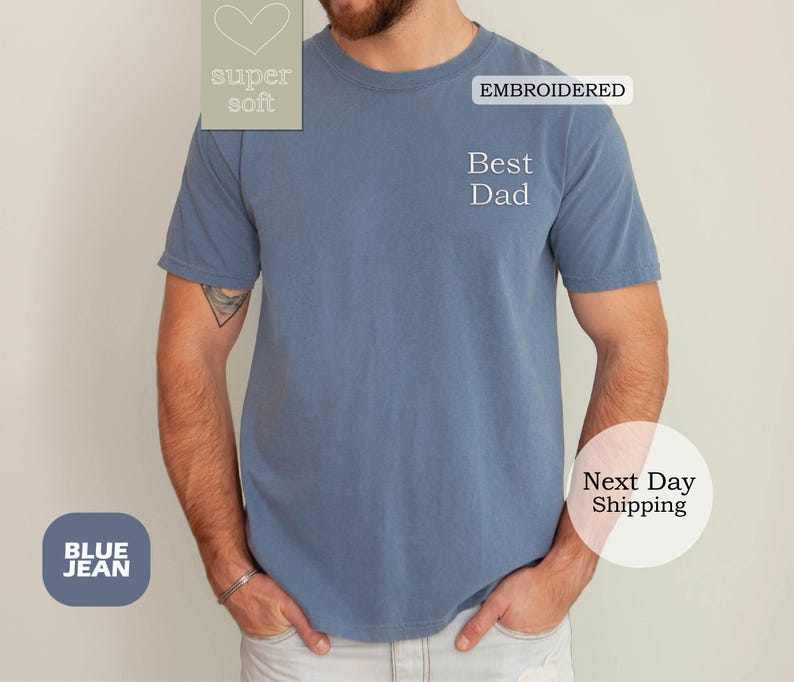 K&ouml;nnte beinhalten: Blaues Jeans-T-Shirt mit dem gestickten Text "Best Dad" auf der Vorderseite. Das Shirt ist super weich und hat ein Herz mit dem Text "super soft" auf der linken Brustseite.