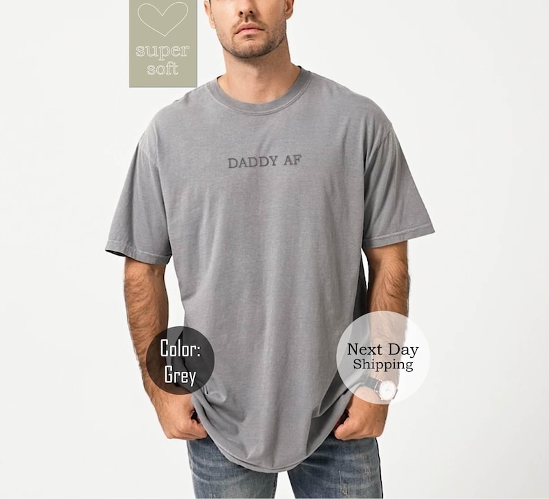 May include: A grey t-shirt with the text "DADDY AF" printed on the front.