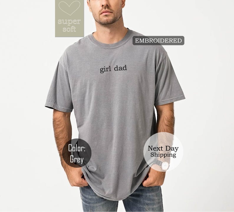 K&ouml;nnte beinhalten: Graues T-Shirt mit dem gestickten Text "girl dad" auf der Vorderseite.