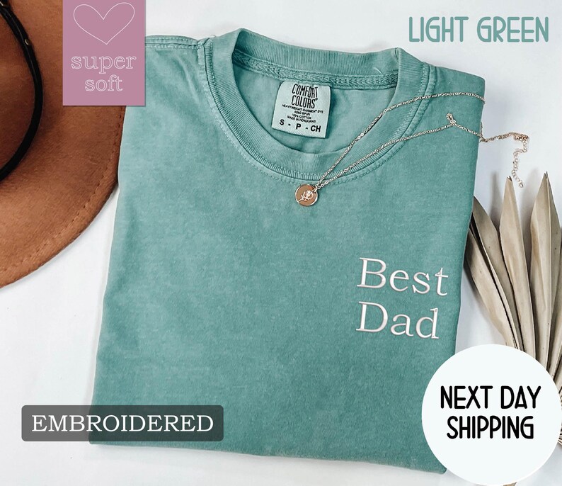 K&ouml;nnte beinhalten: Hellgr&uuml;nes T-Shirt mit dem gestickten Text "Best Dad" in Wei&szlig;. Das Shirt ist super weich und bequem.