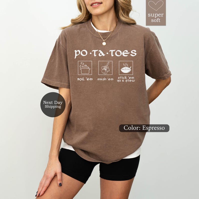 May include: Espresso-colored t-shirt with the word "POTATOES" in white, along with three illustrated cooking steps. The shirt has a crew neck and short sleeves. The text "super soft" is in the upper right corner.