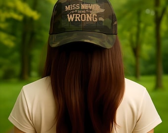 May include: A camouflage baseball cap featuring the text MISS NEVER DO NO WRONG in a light-colored font on the front panel. The cap has a structured crown, a curved brim, and a dark green, brown, and black woodland pattern throughout the fabric.