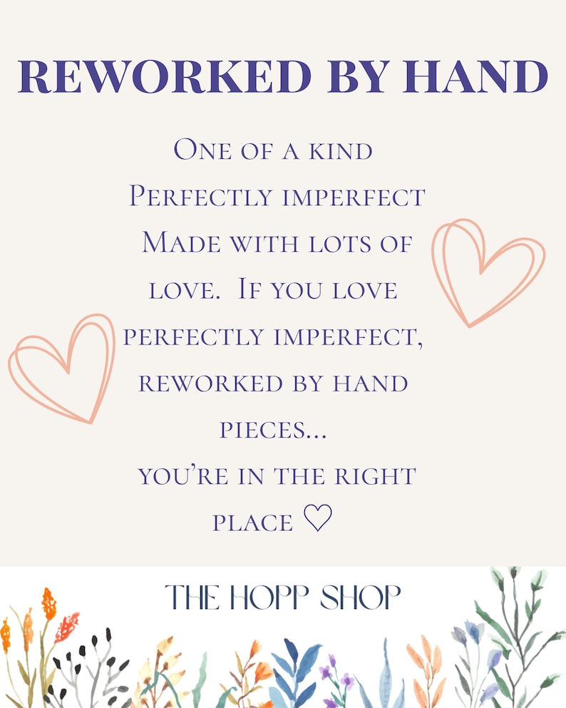 May include: A cream-colored sign with the text "REWORKED BY HAND" in dark blue. The sign includes the phrases "ONE OF A KIND", "PERFECTLY IMPERFECT", and "MADE WITH LOTS OF LOVE". Two pink heart illustrations are on the sign. The shop name "THE HOPP SHOP" is at the bottom.