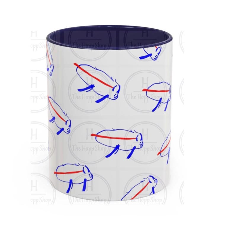 May include: White ceramic mug with a navy blue interior. The exterior features a repeating pattern of blue and red stylized animal illustrations. The text "The Hopp Shop" is visible on the mug.