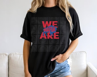 May include: A black short-sleeved t-shirt featuring a graphic print with the red text WE MAFIA ARE and a blue silhouette of a buffalo in the centre. The design is overlaid on a dark grid pattern with repeating circular logos.