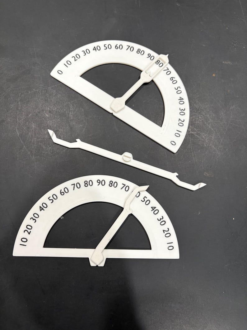 K&ouml;nnte beinhalten: Zwei wei&szlig;e Kunststoff-Winkelmesser mit einem beweglichen Arm. Die Winkelmesser sind mit Zahlen von 0 bis 90 Grad gekennzeichnet.