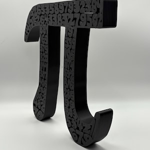 May include: A black, three-dimensional Pi symbol, with the digits of Pi embedded throughout its form. The mathematical symbol is displayed against a white background, showcasing its shape and the numerical details.