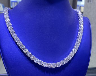 May include: A silver chain necklace with large, round, clear stones. The necklace is displayed on a blue velvet mannequin bust.
