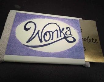 May include: A purple and white chocolate bar wrapper with the word "Wonka" written in cursive.