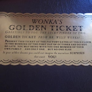 以下が含まれることがあります： 金色のチケットで、装飾的な縁取りと「WONKA'S GOLDEN TICKET」という文字が書かれています。チケットは「幸運な発見者」に宛てられており、10月1日の午前10時に工場の門に来るように招待しています。また、発見者の家族から1人だけ同伴できることが記載されています。