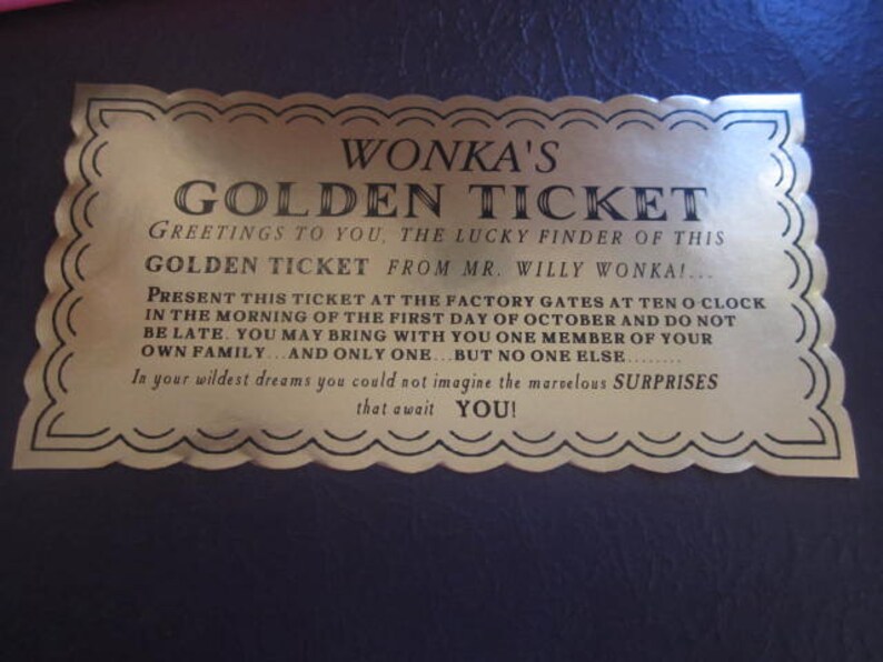 以下が含まれることがあります： 金色のチケットで、装飾的な縁取りと「WONKA'S GOLDEN TICKET」という文字が書かれています。チケットは「幸運な発見者」に宛てられており、10月1日の午前10時に工場の門に来るように招待しています。また、発見者の家族から1人だけ同伴できることが記載されています。