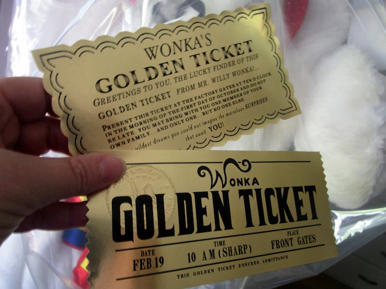 以下が含まれることがあります： 「Wonka's Golden Ticket」と黒文字で書かれた金色のチケットが2枚。 上のチケットは装飾的な縁取りがあり、工場の門でチケットを提示する方法が書かれている。 下のチケットには「Feb 19」の日付と「10 AM (SHARP)」の時間、そして「Front Gates」の場所が書かれている。