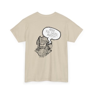 May include: A tan t-shirt featuring a black and white illustration of a pirate with a long beard and a tricorn hat. A speech bubble above the pirate says, "ARRR... YOU SAVED, MATEY?"