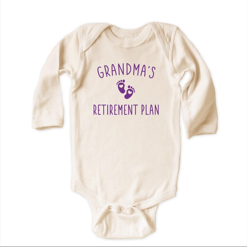 Peut inclure: Un body b&eacute;b&eacute; &agrave; manches longues de couleur cr&egrave;me avec le texte "Grandma's Retirement Plan" et un graphique de traces de pas violet avec un c&oelig;ur dans chaque empreinte.