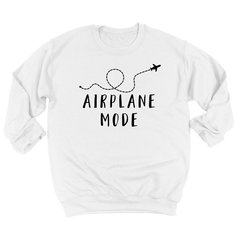 Puede incluir: Sudadera blanca con la frase "AIRPLANE MODE" en negro, acompa&ntilde;ada de una l&iacute;nea de puntos y un avi&oacute;n. El dise&ntilde;o sugiere viajes o un estado de relajaci&oacute;n.