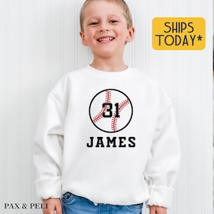 May include: White sweatshirt with a red and white baseball graphic and the number 31. The name James is printed below the baseball.