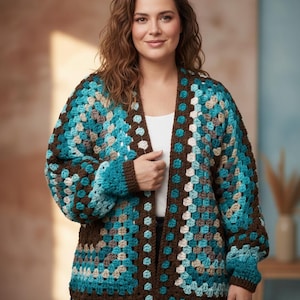 May include: A handmade, open-front cardigan in a granny square pattern. The crochet jacket features a colour palette of teal, brown, and cream. The sleeves are long and the garment is knee-length. The cardigan is a cosy, stylish piece of clothing.
