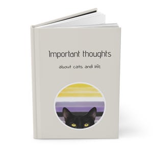 May include: A gray book with the title "Important thoughts about cats and life" printed in black. A black cat with yellow eyes peeks out from behind a circle with a yellow, white, purple, and black striped design.