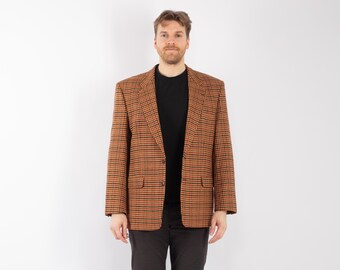 Könnte beinhalten: Ein braun-schwarz karierter Blazer mit einem schwarzen Hemd und einer schwarzen Hose. Der Blazer hat ein klassisches Design mit zwei Vordertaschen und einem fallenden Revers. Das Outfit eignet sich für geschäftliche oder informelle Anlässe.