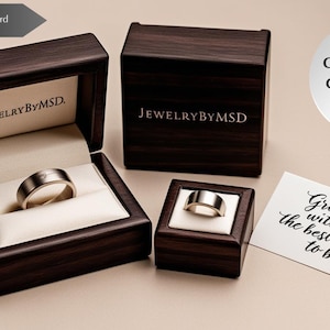 May include: Three dark wooden ring boxes with the JewelryByMSD logo, one open with a silver ring. A gift bracelet is included. A message card reads "Grow old with me, the best is yet to be."