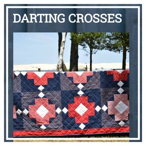 May include: A navy blue quilt with a red and white cross pattern. The quilt features a diamond quilting pattern and a red border. The text "DARTING CROSSES" is at the top of the image.